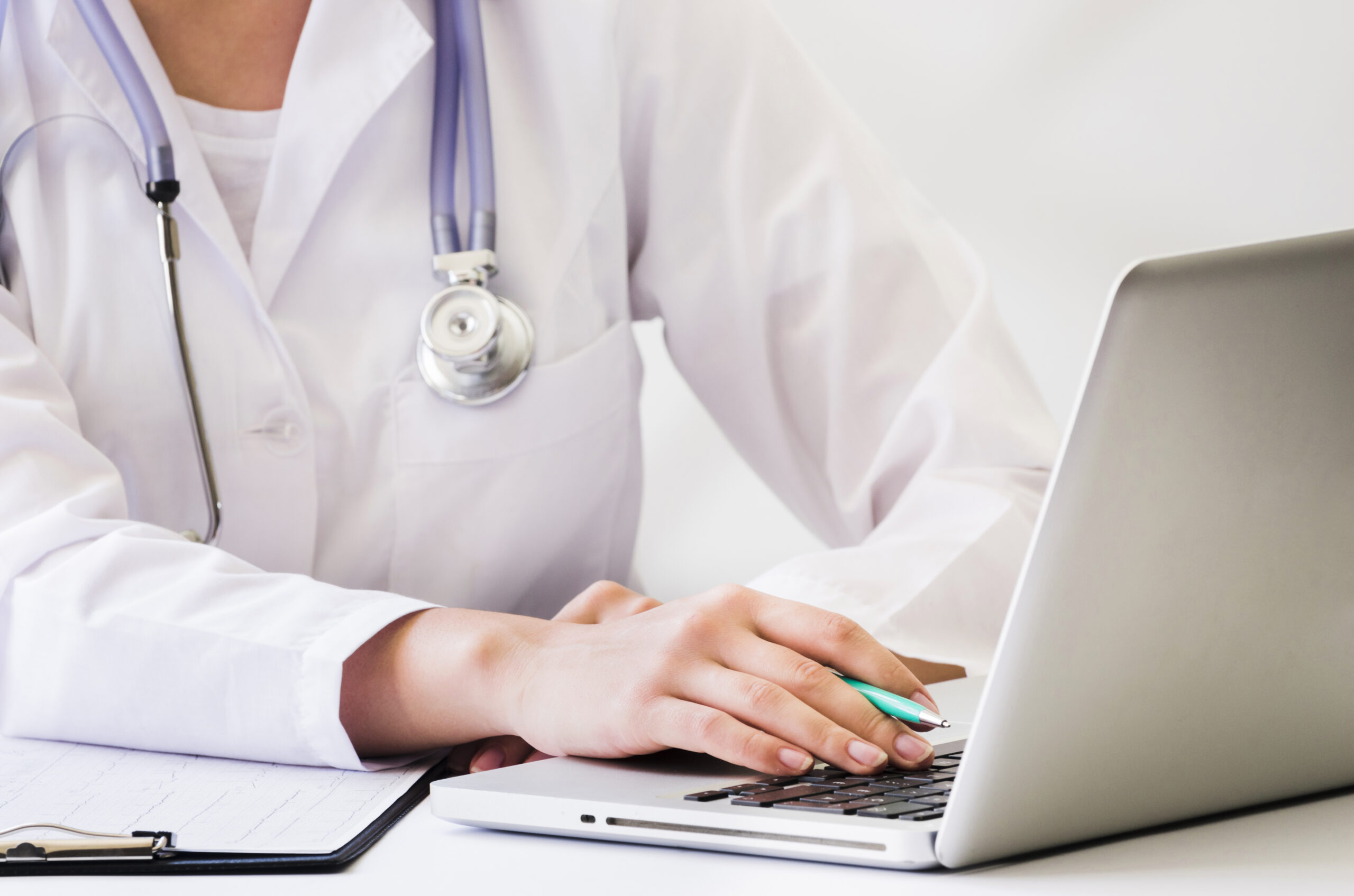 female-doctor-with-stethoscope-around-her-neck-using-laptop-desk